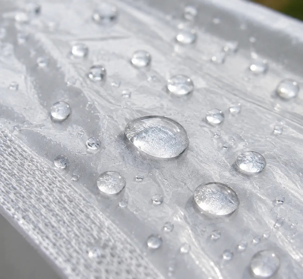 Water droplets on transparent tarp surface