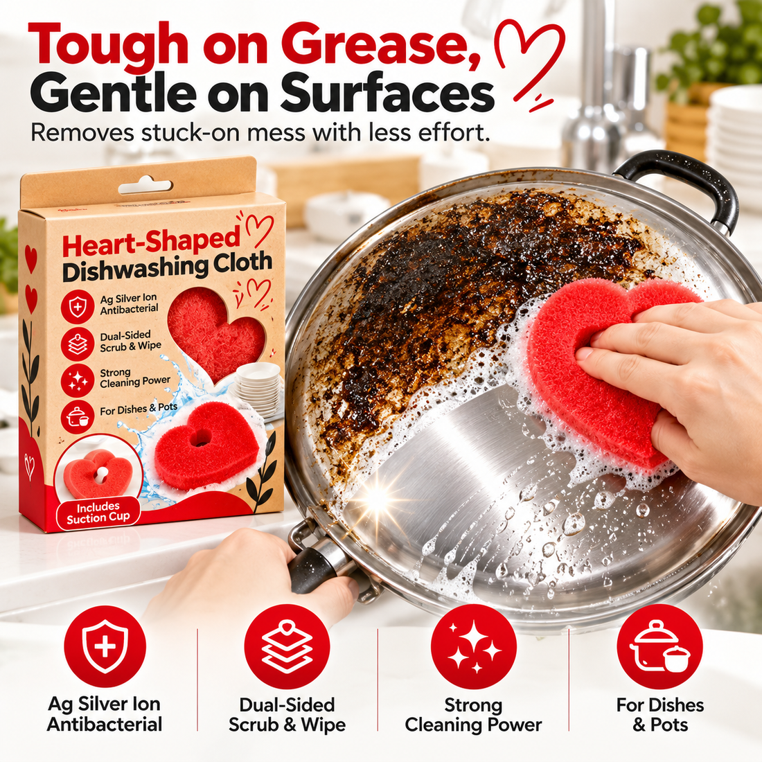 Red heart scrubber cleaning greasy residue from a stainless steel pan